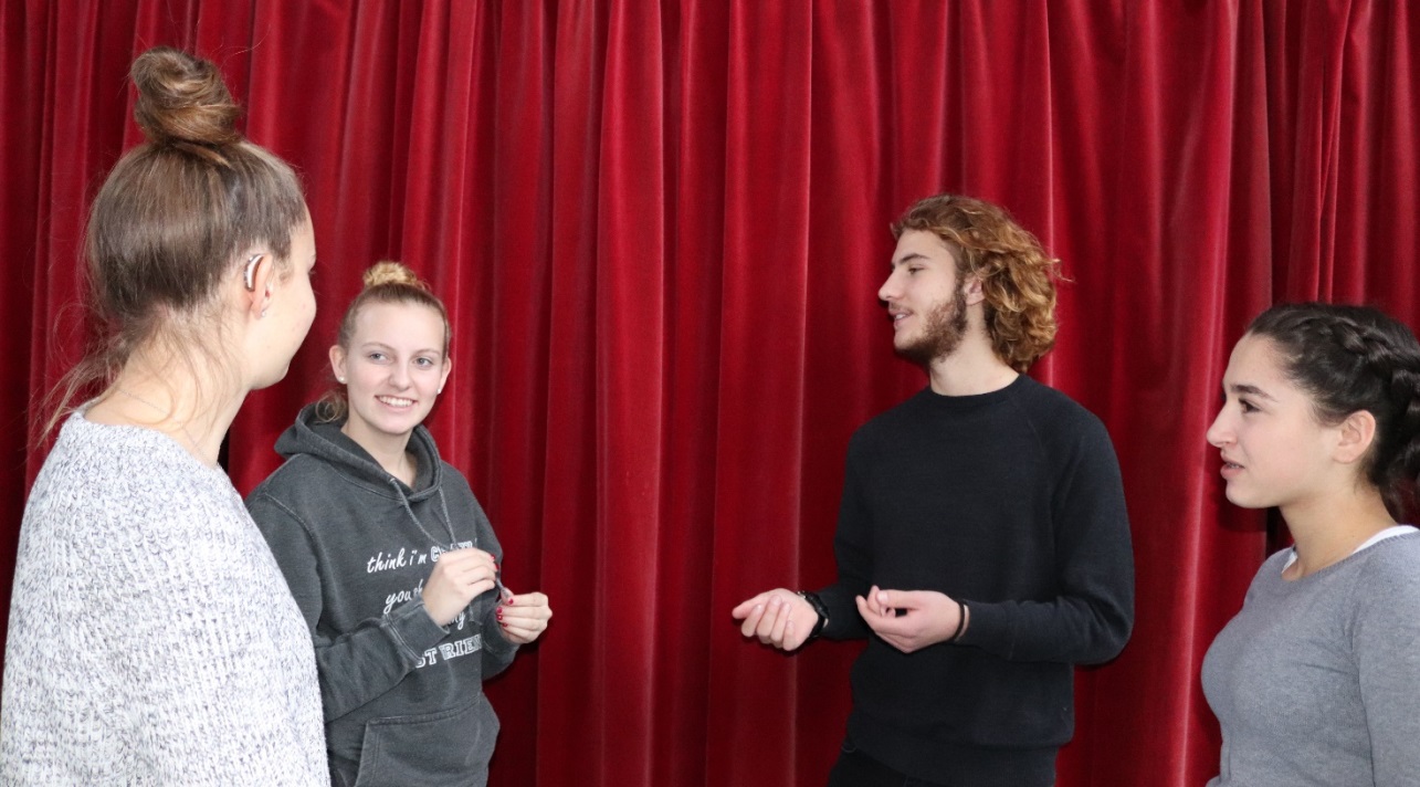 Drei Schülerinnen mit einem Schüler im Gespräch