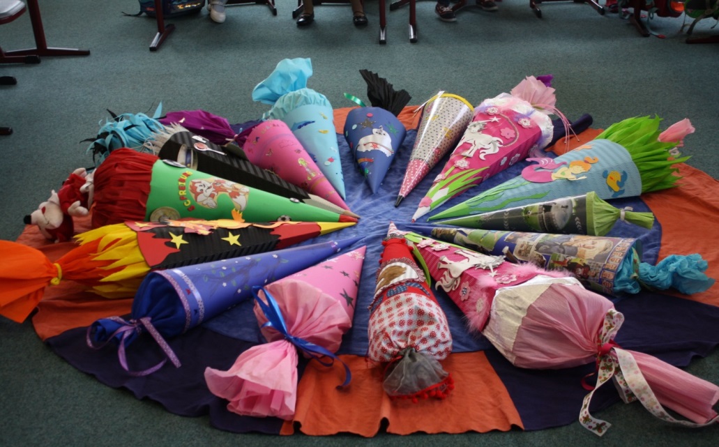 Kreisförmig angeordnete Schultüten liegen im Klassenzimmer auf dem Boden.