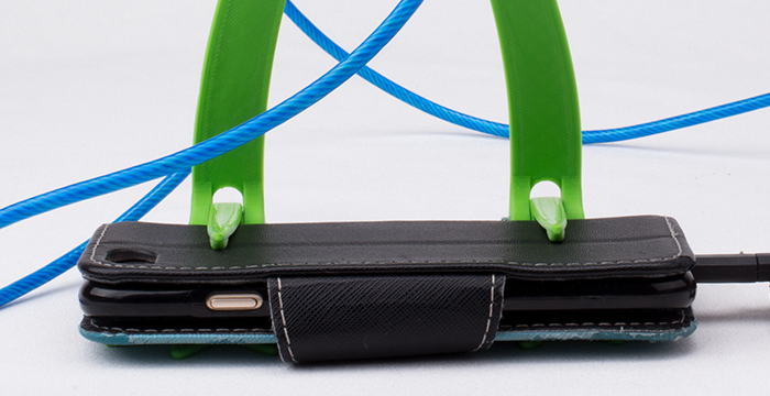 Smartphone in Froschfüßen, mit Kabel