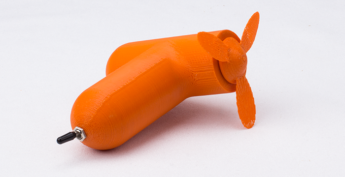 orangener Handventilator ganz, mit Schalter, weiße Unterlage