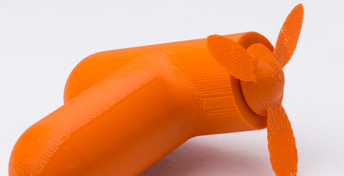 orangener Handventilator angeschnitten, weiße Unterlage