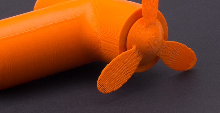 orangener Handventilator angeschnitten, schwarze Unterlage