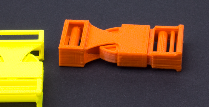 zwei Steckklammern, gelb und orange, auf schwarzem Hintergrund 3