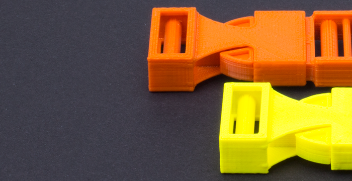 zwei Steckklammern, gelb und orange, auf schwarzem Hintergrund 3