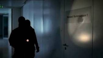 Vermummte richten Taschenlampe auf Tür