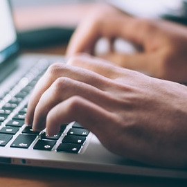 Hände auf einer Laptoptastatur